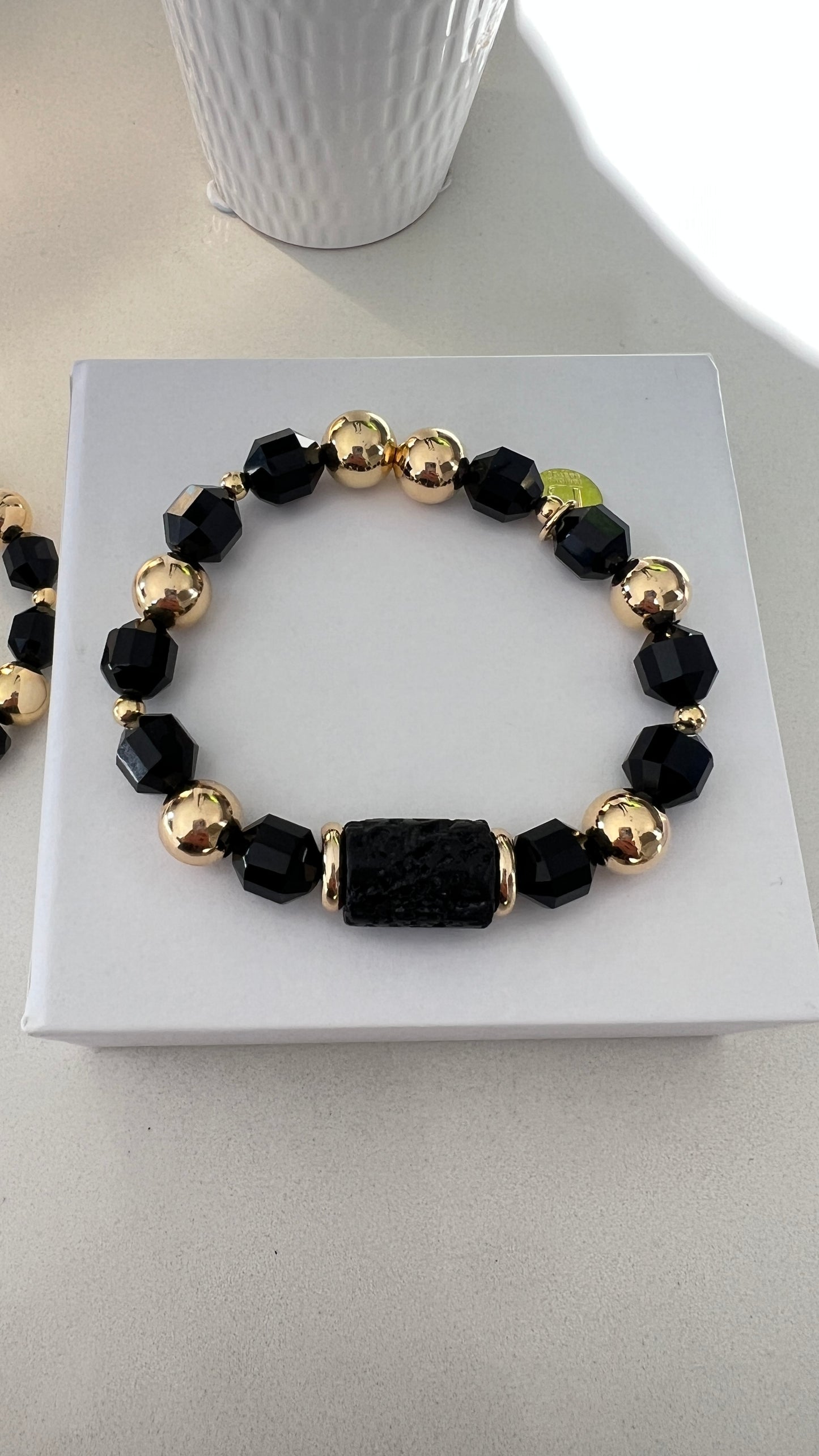 Pulsera negra y dorada con piedra Volcanica